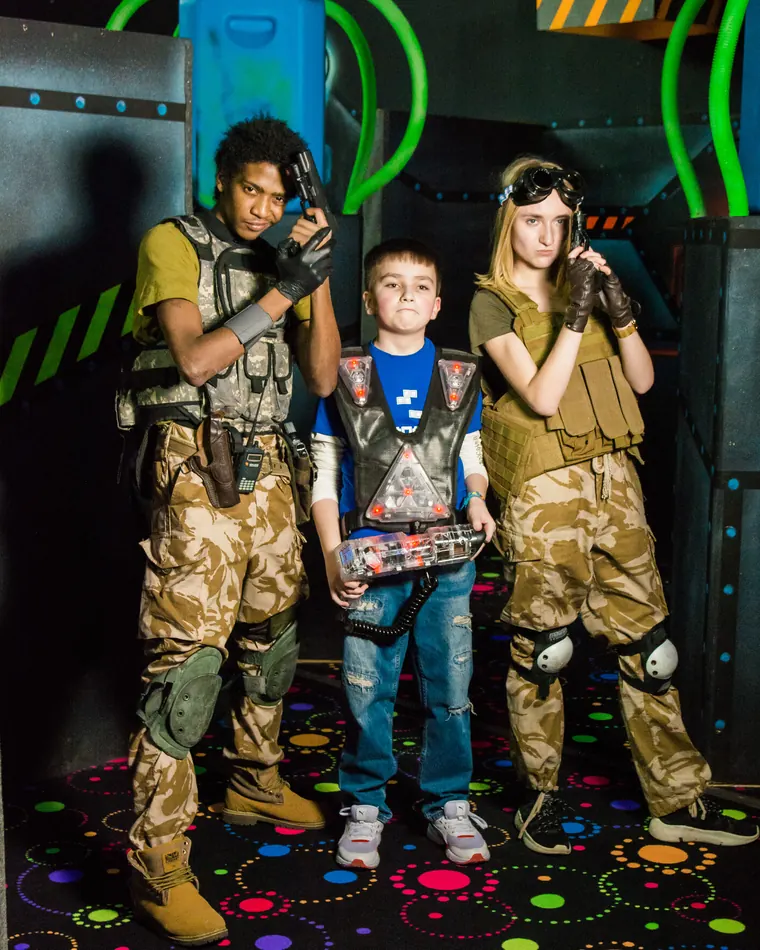 Ведущие квеста и участник в игровой экипировке в центре LaserLand