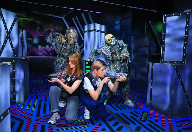 Игроки целятся в актёров-зомби на арене LaserLand